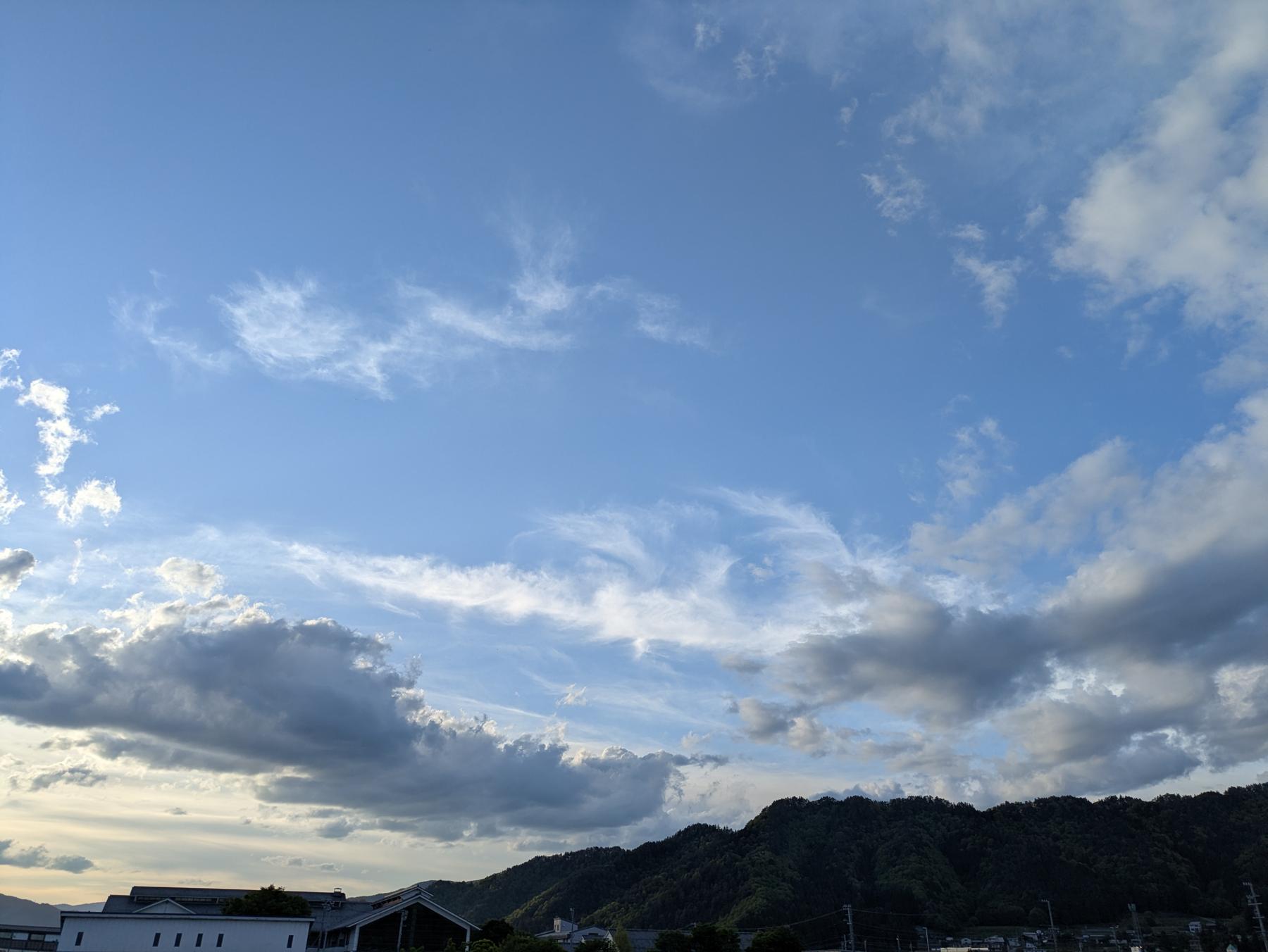 夕方の青空に広がる雲と、その下の山並み